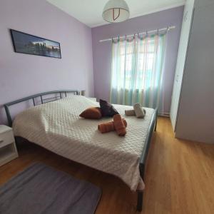 a bedroom with a bed with two stuffed animals on it at Apartments Piglić in Lovran +16 photos