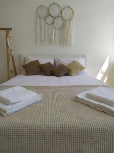 Una cama con sábanas blancas y almohadas. en Belle Art Hotel en Odesa