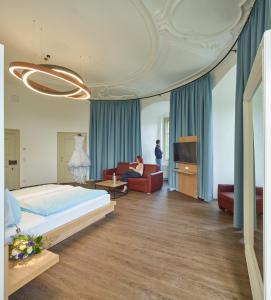 a bedroom with a bed and a person sitting on a couch at Schloss Weinberg in Kefermarkt +45 photos