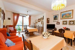 B&B Al Giardino في مونريالي: غرفة معيشة مع أثاث برتقالي وغرفة طعام