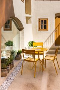 a table and chairs on a patio with plants at Kai 36 - Hotel zwischen Fels und Fluss in Graz