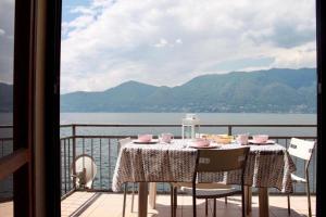 stół na balkonie z widokiem na wodę w obiekcie Casa Spiaggia w mieście Brezzo