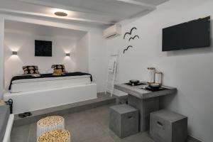 a bedroom with a bed and a tv on the wall at Peter's Sea and Sαnd Residence in Adamas