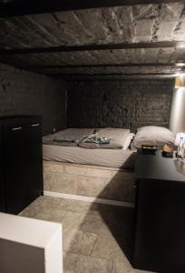 a bedroom with a bed in a stone wall at DarkHouse in Łódź