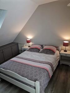リュス・サン・ソヴァールにあるAppartement Aline et Philのベッドルーム1室(ベッド1台、ランプ2つ、テーブル2台付)