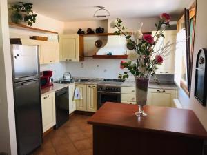 a kitchen with a vase of flowers on a table at Casa del Balcone Fiorito in Cormòns