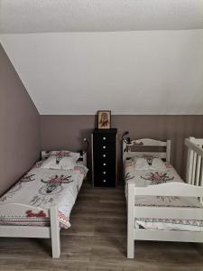 a bedroom with two beds and a dresser at Appartement Aline et Phil in Luz-Saint-Sauveur