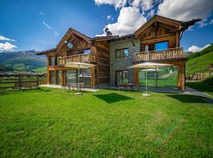 a log house with a lawn in front of it at Chalet La Dolce Vita MyHoliday in Livigno