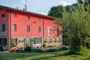 a red house with a fence in front of it at Al Sasseto B&B in Montagnana