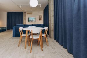 uma mesa e cadeiras num quarto com um sofá azul em loft Apartmen em Sumy