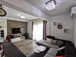 - un salon avec un canapé et une télévision dans l'établissement Apartment Baćo, à Podstrana