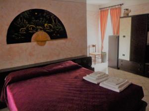 a bedroom with a bed with two towels on it at L'Elefantino - Bed and Book in Roccasparvera