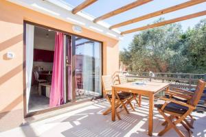 een patio met een houten tafel en stoelen op een balkon bij Apartman Cone in Pula