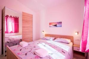een slaapkamer met 2 bedden en roze lakens bij Apartman Cone in Pula