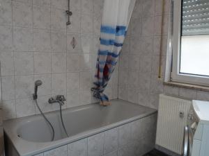 a bath tub in a bathroom with a shower curtain at Schöne Wohnung in Fürth