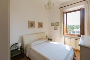 una camera bianca con un letto e una finestra di Casa Germana by HelloElba a Portoferraio