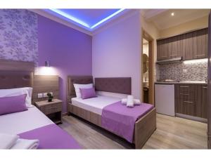 托羅尼的住宿－House Diakos Toroni，一间紫色卧室,配有两张床和一间厨房