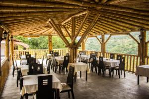 un restaurant avec des tables et des chaises et un plafond en bois dans l'établissement Hotel Terrazas de la Candelaria, à San Gil