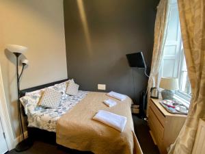 a bedroom with a bed and a desk at 16 Pilrig Guest House in Edinburgh