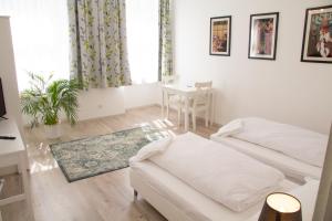 ein weißes Wohnzimmer mit einem Sofa und einem Tisch in der Unterkunft Vienna4you App 15 you are welcome in Wien