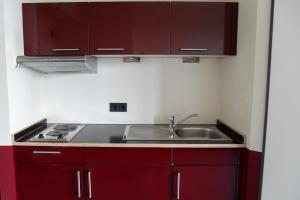 a kitchen with red cabinets and a sink at Base Apartments in Hamburg