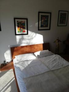 a bedroom with a large bed with white sheets at Rob´s Place in Langenfeld