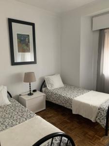 ポルトにあるA Casa das Margaridasのベッド2台、ランプ1台が備わる客室です。