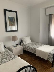 a room with two beds and a lamp on a table at A Casa das Margaridas in Porto