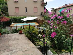 a garden with a swimming pool and pink flowers at Lucky House in La Spezia