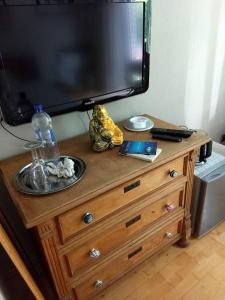 eine hölzerne Kommode mit einem TV darüber in der Unterkunft Rob´s Place in Langenfeld