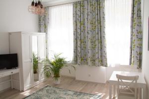 a living room with a table and a window with curtains at Vienna4you App 15 you are welcome in Vienna