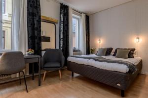 a bedroom with a bed and a desk and a chair at Hotel Park Allé in Kristianstad