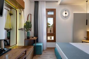 Schlafzimmer mit einem Bett, einem Schreibtisch und einem Fenster in der Unterkunft Camere Maritima in Chania