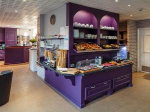 Noemys Valence Nord - hotel restaurant في بور ليه فالينس: مخبز مع منضدة أرجوانية مع طعام عليها