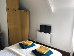 a bedroom with a bed with two towels on it at ardoises et agapanthes in Pleslin-Trigavou