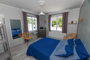 1 dormitorio con 1 cama azul y 2 sillas en Résidence Romaric, en Jard-sur-Mer