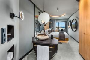 a master bedroom with a bed and a bathroom at Hotel Faro, a Lopesan Collection Hotel - Adults Only in Maspalomas