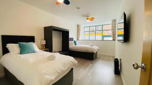 a bedroom with two beds and a window and a door at Second Nest Ramsgate in Ramsgate
