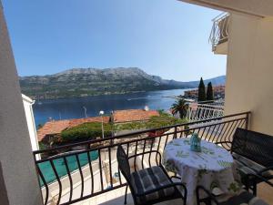 a balcony with a table and chairs and a view of the water at Apartments Adriatic in Korčula