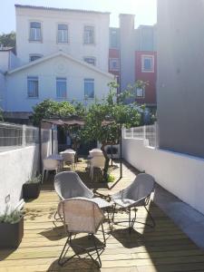 een patio met stoelen en tafels op een balkon bij Coimbra Monumentais B&B in Coimbra