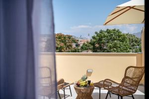 a patio with chairs and a table with bananas on it at Camere Maritima in Chania Town