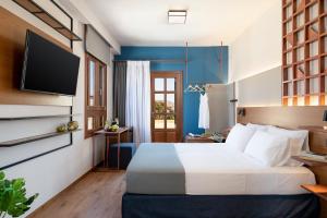ein Hotelzimmer mit einem Bett und einem Flachbild-TV in der Unterkunft Camere Maritima in Chania