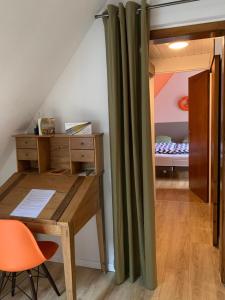 a room with a desk and a bedroom with a bed at La Parenthese in Gertwiller