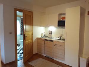 Putterer Stadl في دونيغسباشوالد: مطبخ صغير مع حوض وميكروويف +صورتان