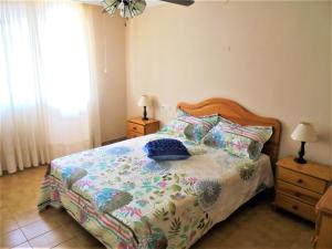 a bedroom with a bed with a colorful comforter and pillows at Residencial Toboso LEK in Peniscola