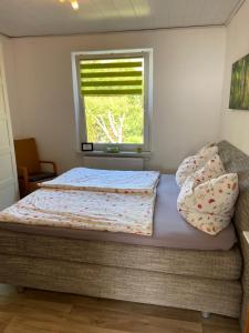 a bedroom with a bed with a window and pillows at Dat Sottje Huus in Wilhelmshaven
