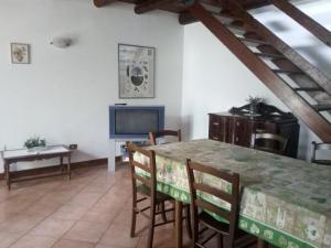 a dining room with a table and a television at La corte del pane in Valbrona