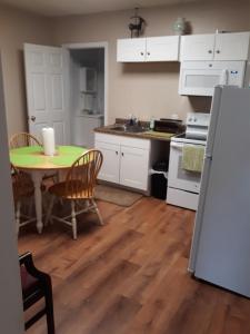 uma cozinha com uma mesa e um frigorífico branco em Northern Peaks Motor Inn em Gorham