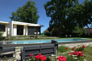 una casa con piscina y algunas flores en Chambre BEAUSEJOUR, en Brive-la-Gaillarde