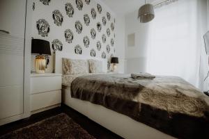 1 dormitorio con 1 cama y una pared de platos en Grand LuxuryB&B -Piotrkowska St Free Parking en Lodz